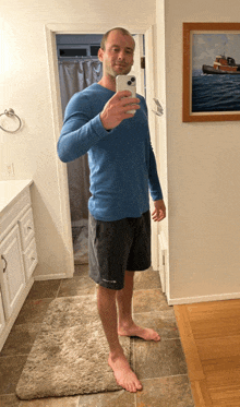 a man in a blue shirt is taking a selfie