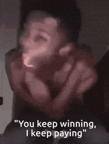 a blurry picture of a man with the words " you keep winning i keep paying " on the bottom