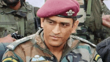 a man in a military uniform is wearing a red beret and standing in front of a group of soldiers .