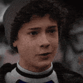 a young boy with curly hair wearing a gray hat