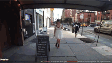 a woman in a white dress is walking down a sidewalk in front of a sign that says tonight 's menu