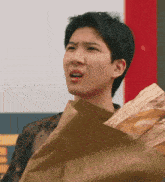 a man is holding a bag of bread that says ' french ' on it