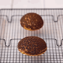 two chocolate covered pastries are sitting on a wire rack