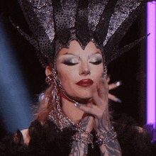 a woman with a crown on her head has a tattoo on her hand