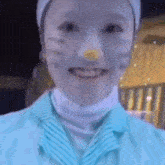 a close up of a person 's face with a cat mask on .