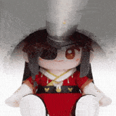 a stuffed doll wearing a red dress and a hat