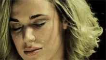 a close up of a woman 's face with a tear coming out of her eye