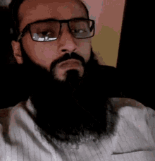 a man with glasses and a beard is looking at the camera