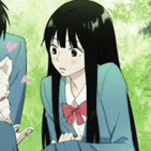 a girl with long black hair is sitting next to a boy in a blue suit holding a cat .