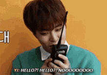 a young man is holding a walkie talkie in his hand .