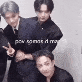 a group of young men in suits are posing for a picture .