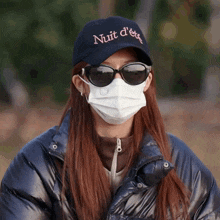 a woman wearing a mask and a hat that says nuit d ' eti