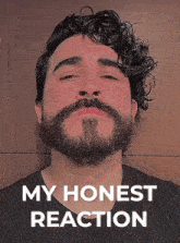 a man with a beard and curly hair is making a funny face with the words my honest reaction behind him