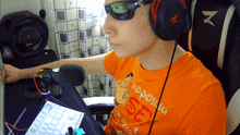 a man wearing headphones and an orange shirt that says sex on it