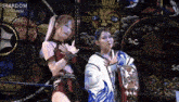 two women standing next to each other in front of a stardom sign