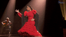 a woman in a red dress is dancing in front of a man playing a guitar with the word talent on the bottom right