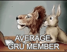 a lion and a rabbit are sitting at a desk looking at a laptop computer .