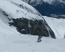 a person on a snowboard going down a snowy hill