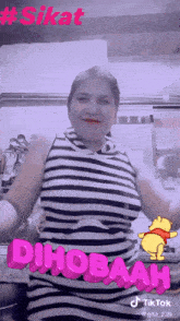 a woman in a black and white striped dress is dancing with a winnie pooh sticker