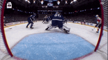 a hockey game is being played in a stadium with the number 60 on the goalie 's jersey