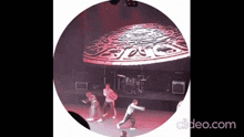 a group of people are dancing on a stage in front of a large screen that says spice