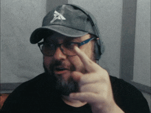 a man with a beard wearing a hat and headphones