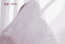 a woman covering her face with a white cloth with chinese writing on the bottom