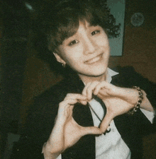 a young man making a heart with his hands
