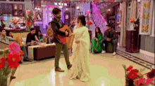 a man is playing a guitar while dancing with a woman in a white dress