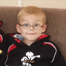 a young boy wearing glasses and a sweatshirt that says wrd