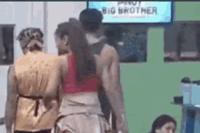 a group of people are standing next to each other in front of a sign that says big brother .
