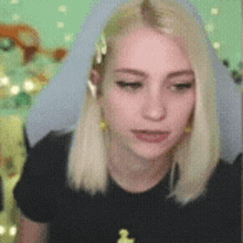 a woman with blonde hair is wearing a black shirt and earphones .