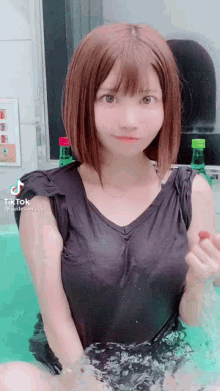 a woman is sitting in a bathtub with a bottle of soda in her hand and a tik tok watermark