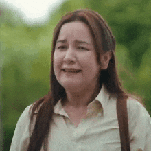 a woman is crying while holding a purse and smiling .