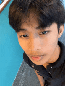 a close up of a young man 's face wearing a polo shirt