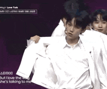 a group of young men are standing next to each other on a stage and one of them is wearing a white shirt .