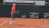 a man holding a tennis racquet on a tennis court with a perrier sign in the background
