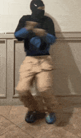 a man in a ski mask is dancing in a room .