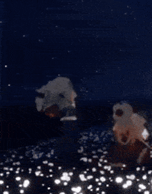a couple of people are standing in the water at night .