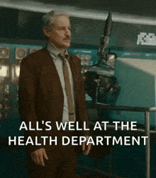 a man in a suit and tie is standing in a room with a robot .