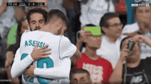 two soccer players are hugging each other while a fan takes a picture