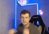 a man is sitting in an akracing chair in a room