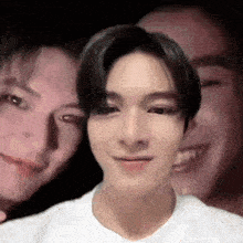 a group of people are posing for a picture together and one of them is wearing a white shirt .