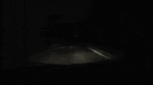 a black and white photo of smoke coming out of a hole in a dark room .