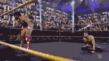 two wrestlers in a wrestling ring with the w logo on the bottom