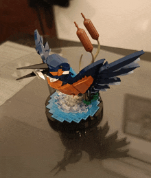 a statue of a bird made out of lego sitting on a table