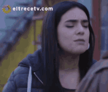 a close up of a woman 's face with eltrecetv.com on the bottom