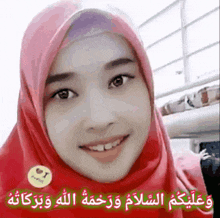 a woman wearing a red hijab and a badge that says i love you is smiling