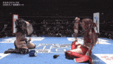 two women wrestling in a ring with a sign that says regional ling on it