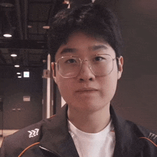 a young man wearing glasses and a jacket that says pkv on it
